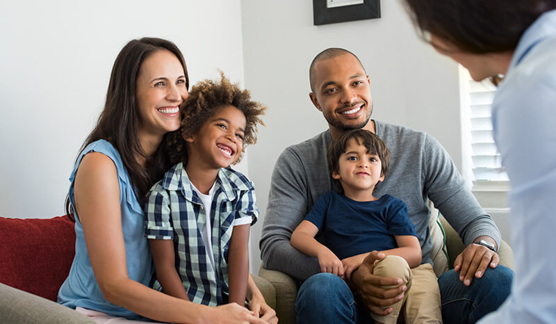 Family with young children talking to insurance professional