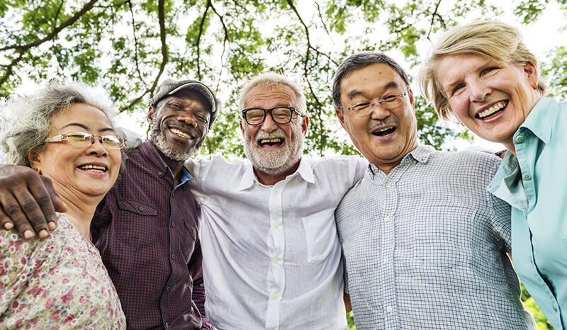 Seniors smiling, arms around each other, retirement planning